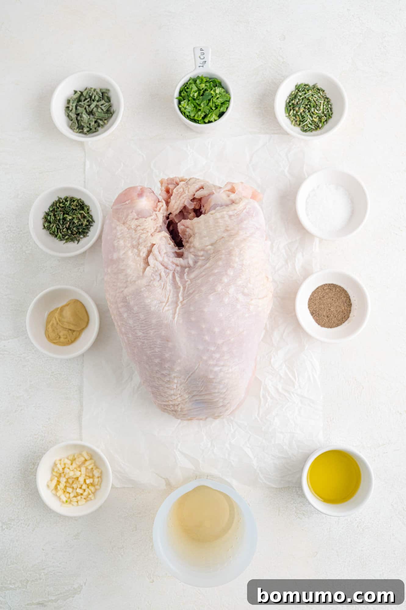 A vibrant flat lay of all the ingredients needed for the herb roasted turkey breast recipe, including a bone-in turkey breast, fresh herbs, garlic, Dijon mustard, and olive oil.
