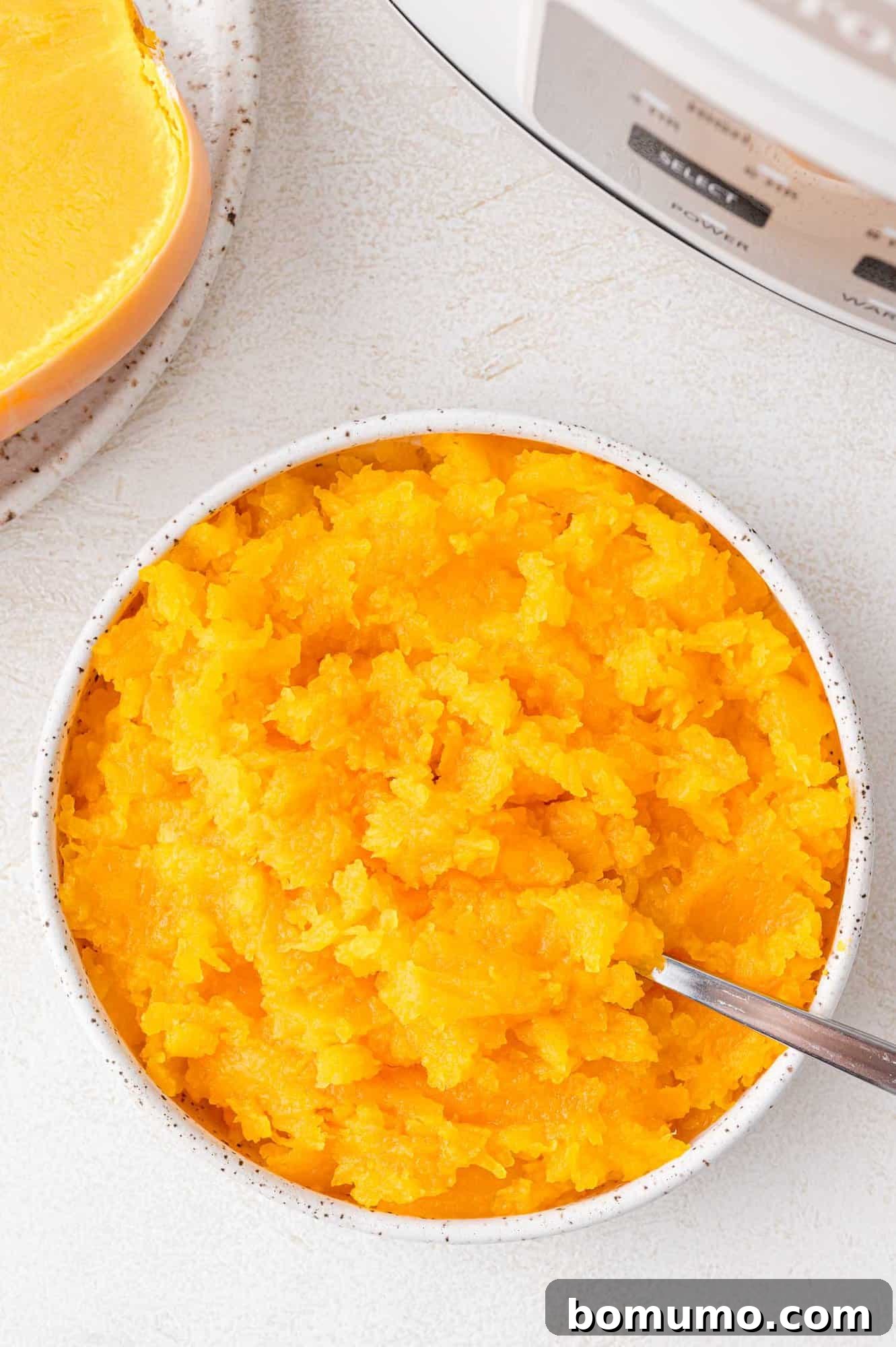 Cooked butternut squash in a large white bowl, ready to be enjoyed.