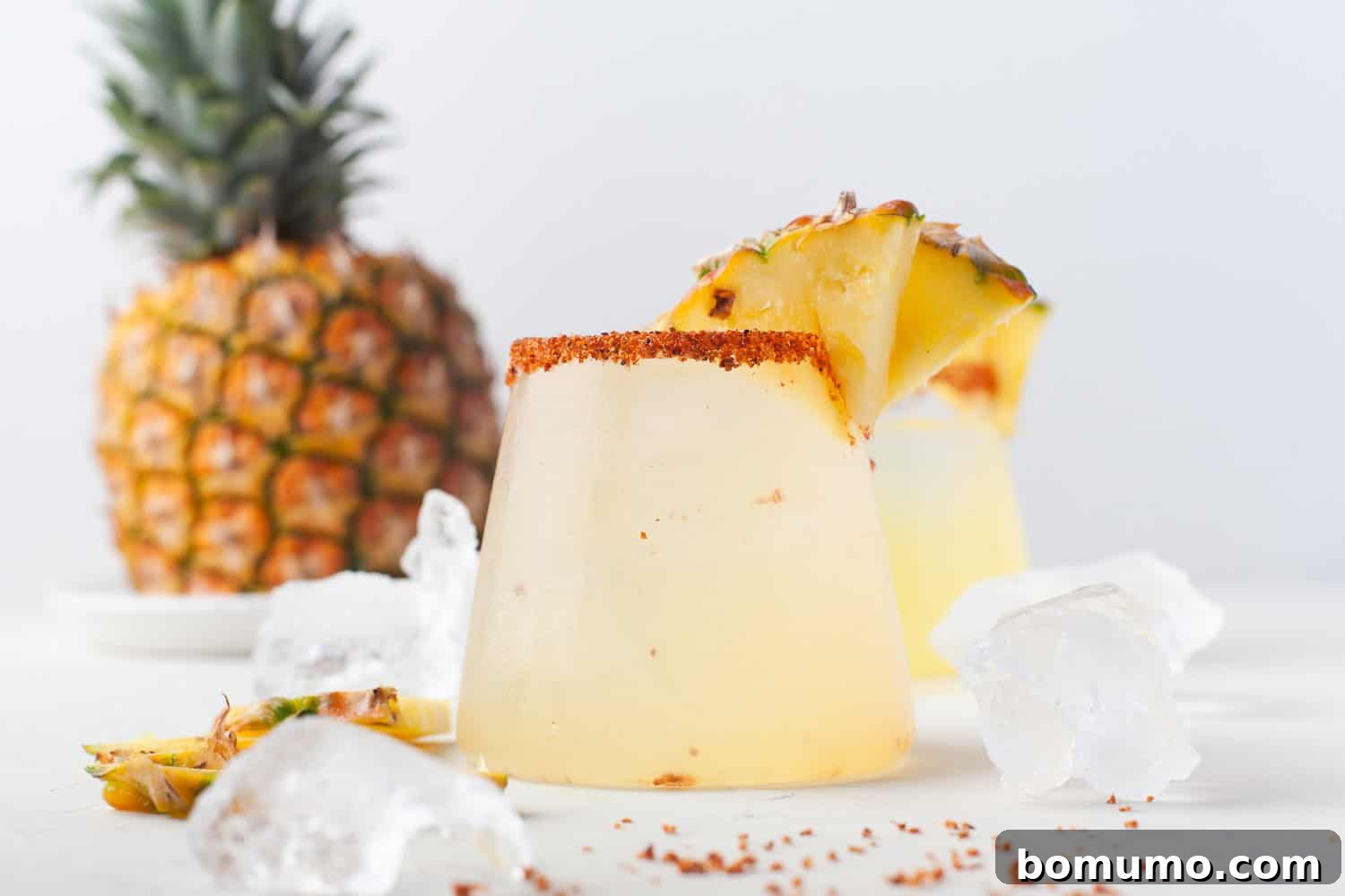 A vibrant pineapple margarita, garnished with a fresh pineapple wedge, sits invitingly, ready to be enjoyed.