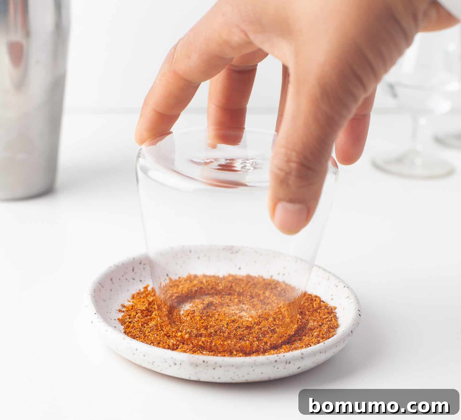 The agave-coated glass rim is then carefully rolled in Tajín seasoning, ensuring an even and flavorful coating for the pineapple margarita.