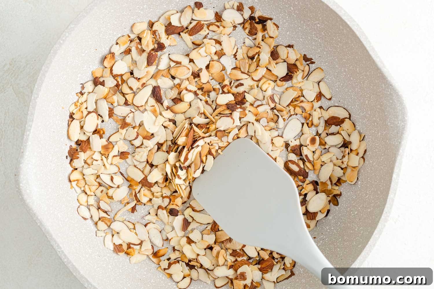 Toasting almonds is a great way to bring out their crunch and flavor. Learn how to toast almonds in the oven, microwave, and on the stovetop! A spatula stirring almonds as they toast in a skillet.