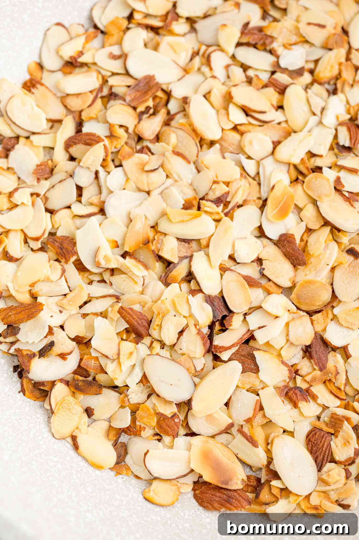 Toasting almonds is a great way to bring out their crunch and flavor. Learn how to toast almonds in the oven, microwave, and on the stovetop! Close up of toasted almonds in a bowl.