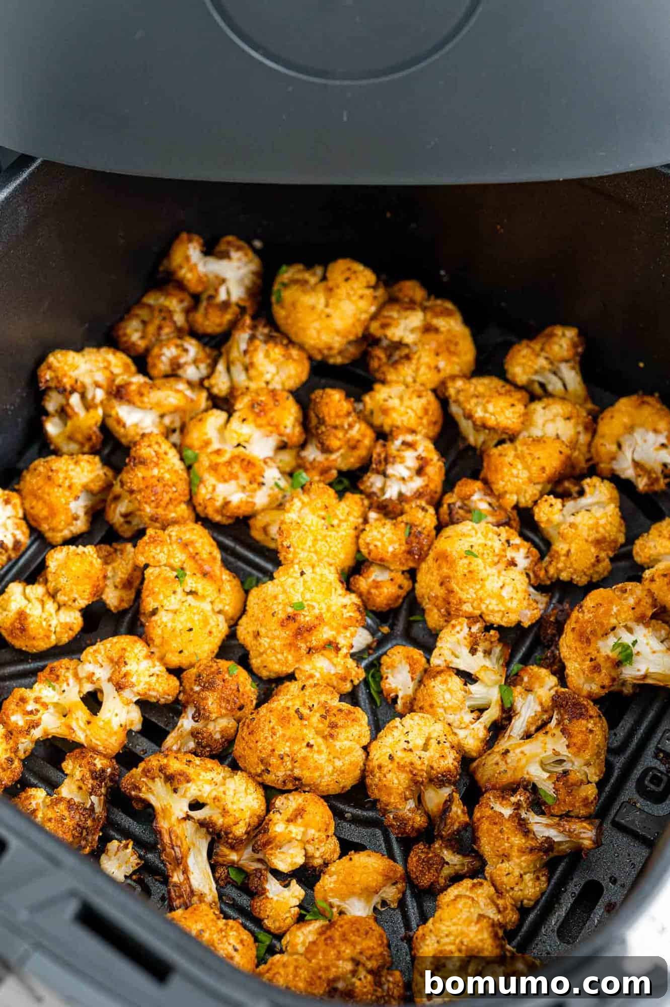 Crispy cauliflower inside the air fryer basket.