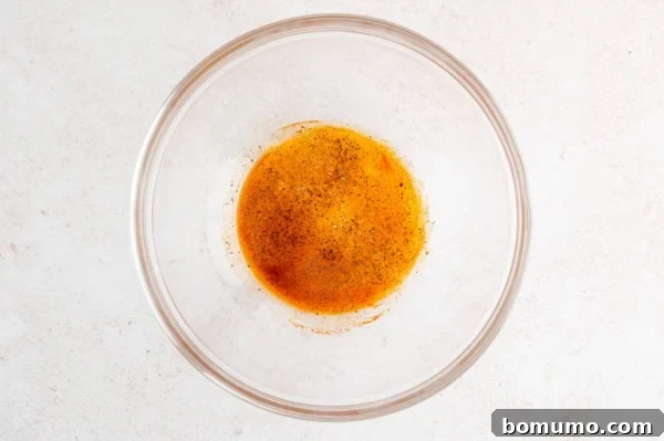 Oil and seasonings in a glass bowl.