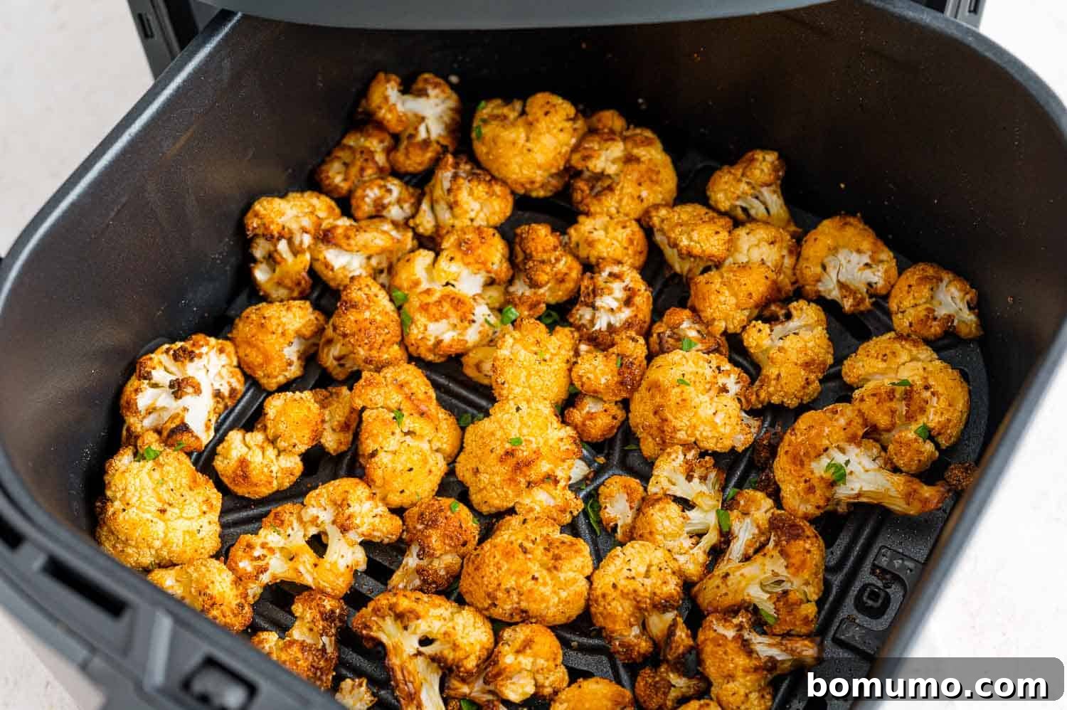 Crispy cauliflower inside the air fryer basket.