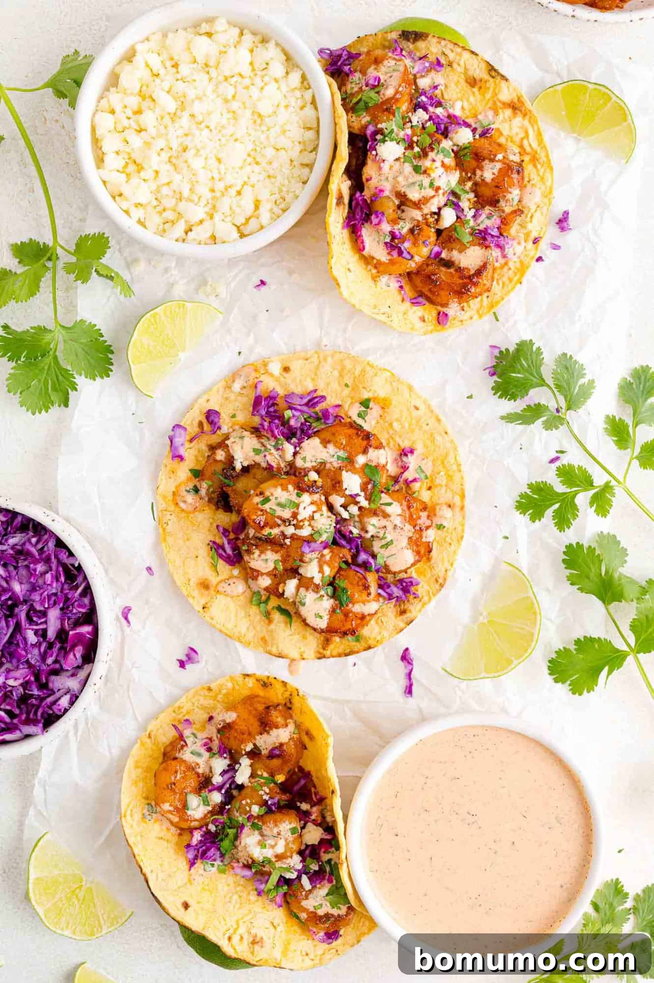 Assembled shrimp tacos laid flat, showcasing the vibrant filling and toppings.