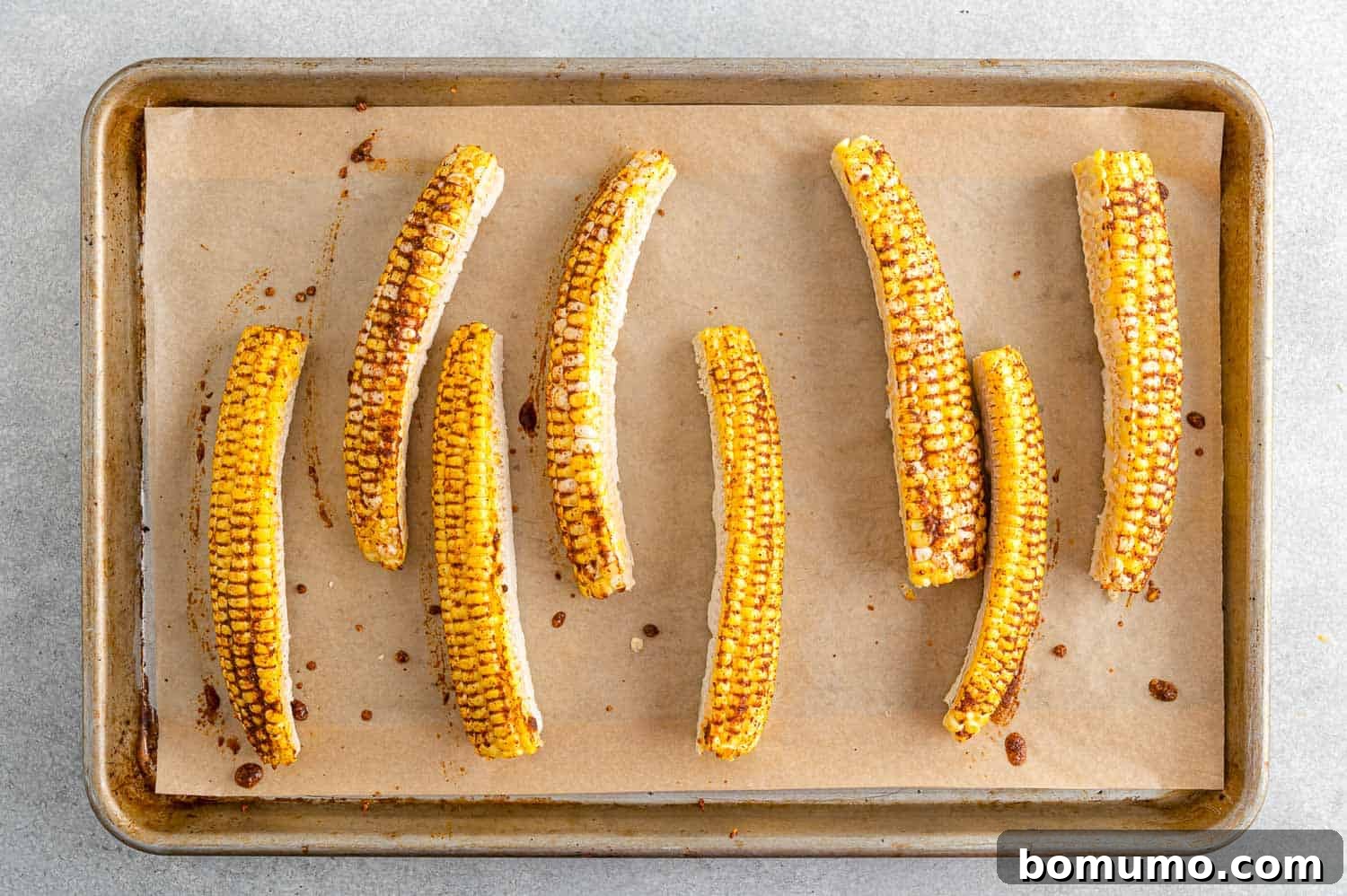 Seasoned uncooked corn ribs, brushed with spices and oil, ready for baking or air frying.
