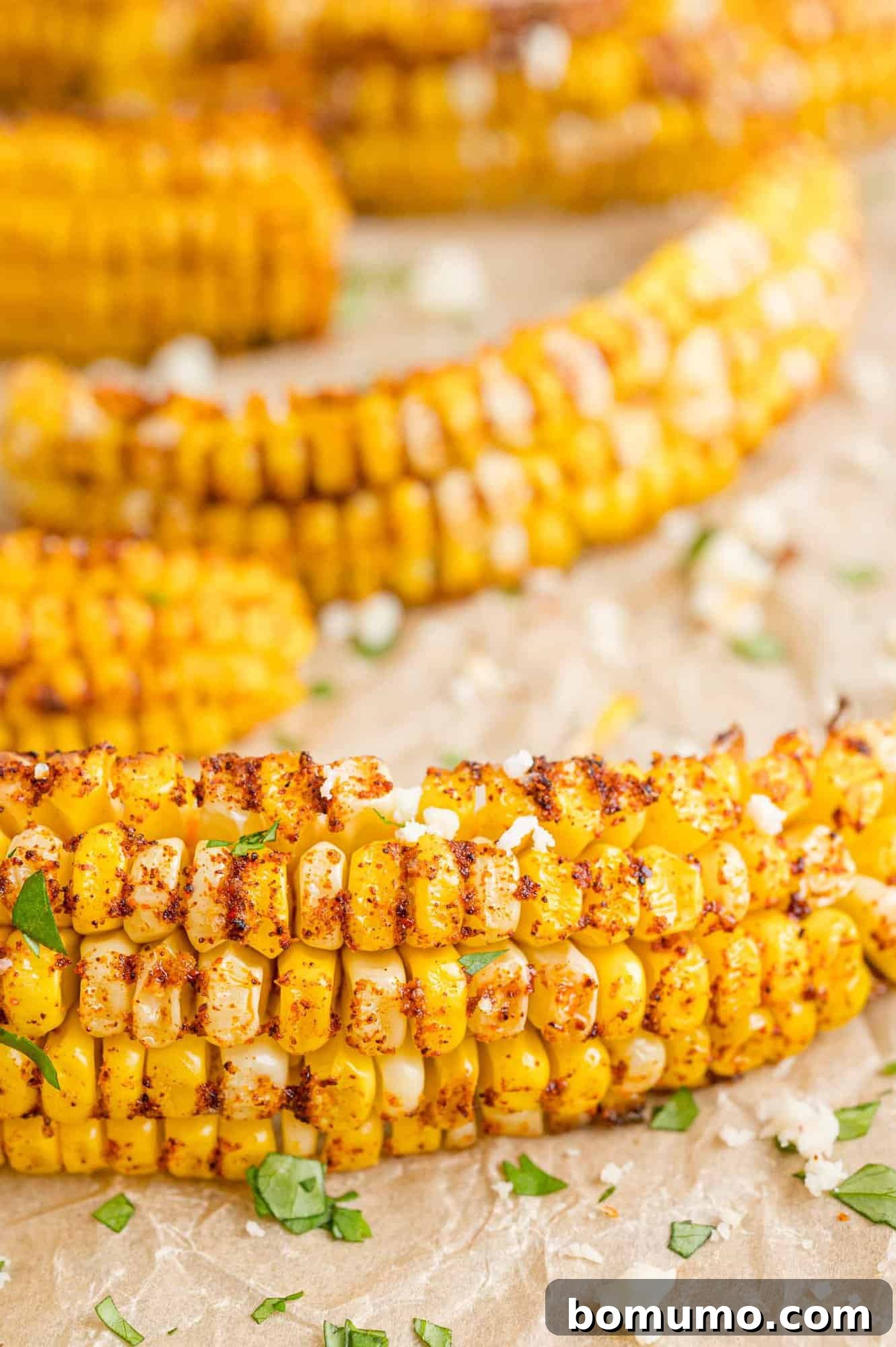 Roasted corn ribs served with crumbled cotija cheese and fresh cilantro, garnished with lime wedges.