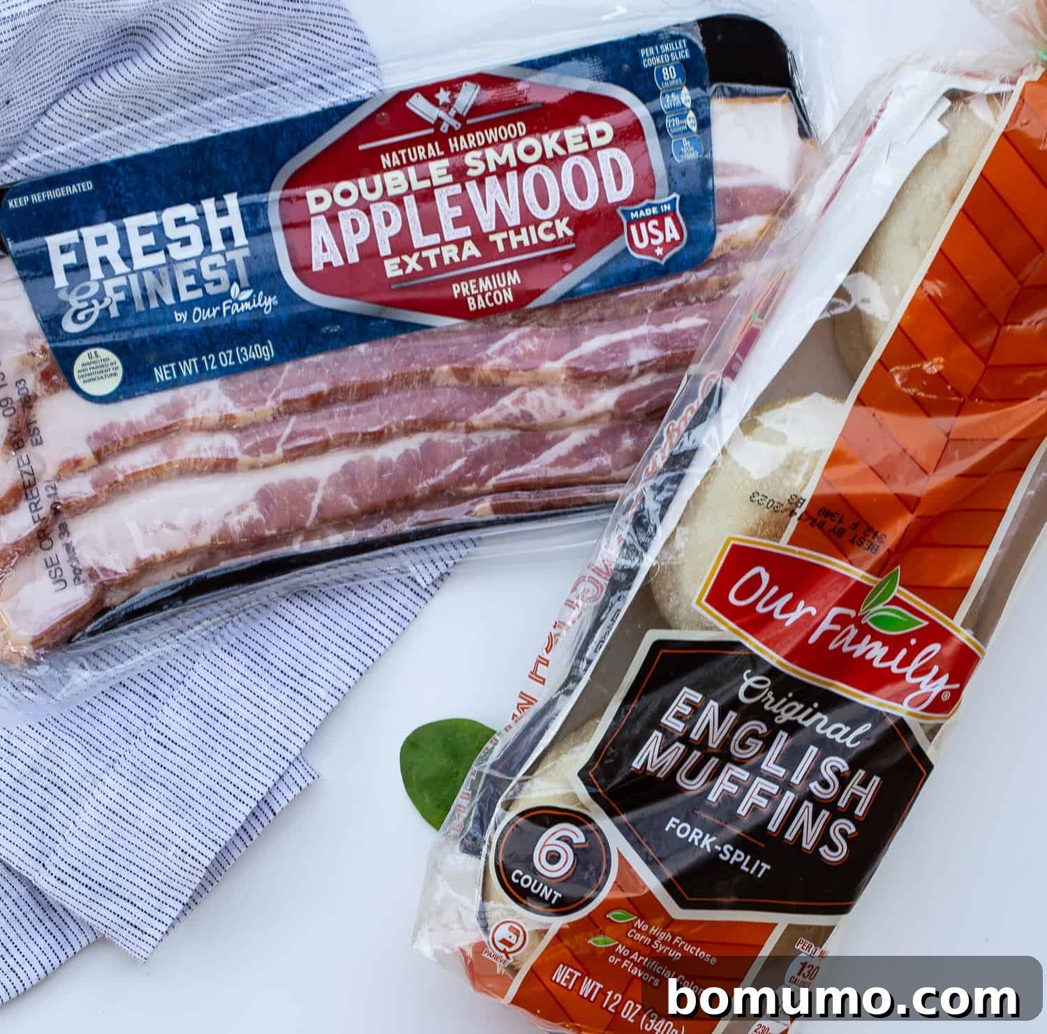 Crispy baked bacon slices and perfectly toasted English muffins, glistening with butter, arranged on a serving plate, ready to accompany the quiche.