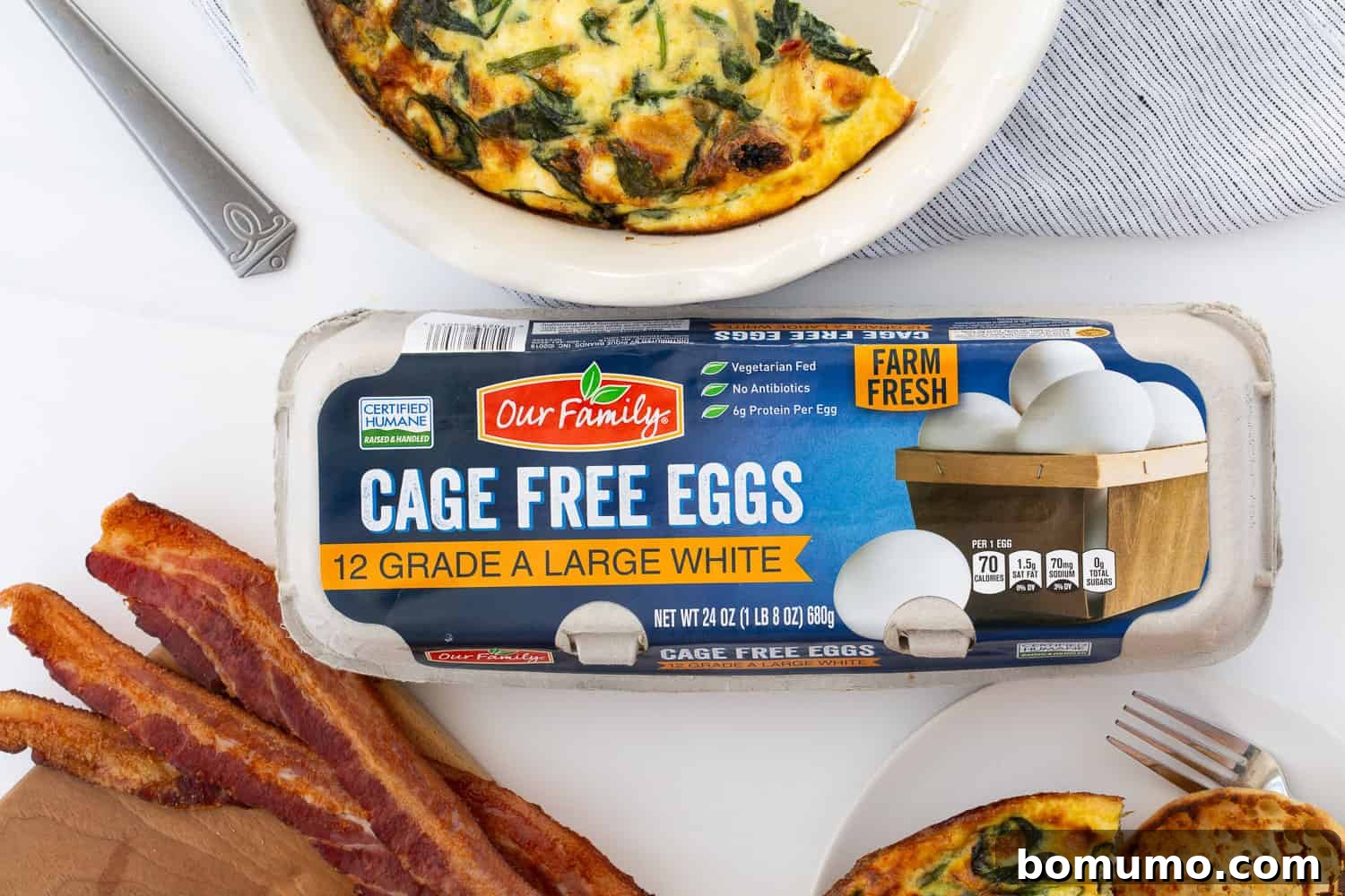 A close-up view of the golden-baked crustless quiche, highlighting its rich, creamy egg center speckled with savory spinach, caramelized onions, and sun-dried tomatoes. The top is lightly browned, indicating perfect doneness.