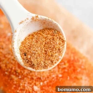 Salmon seasoning being sprinkled on a fresh salmon fillet.