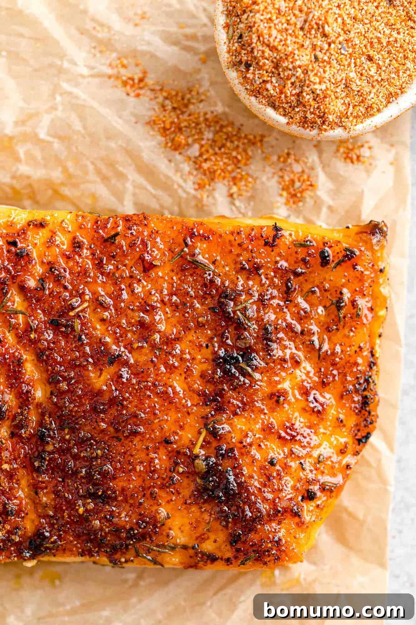 A perfectly broiled salmon fillet, beautifully seasoned and cooked to flaky perfection, resting on a serving plate.