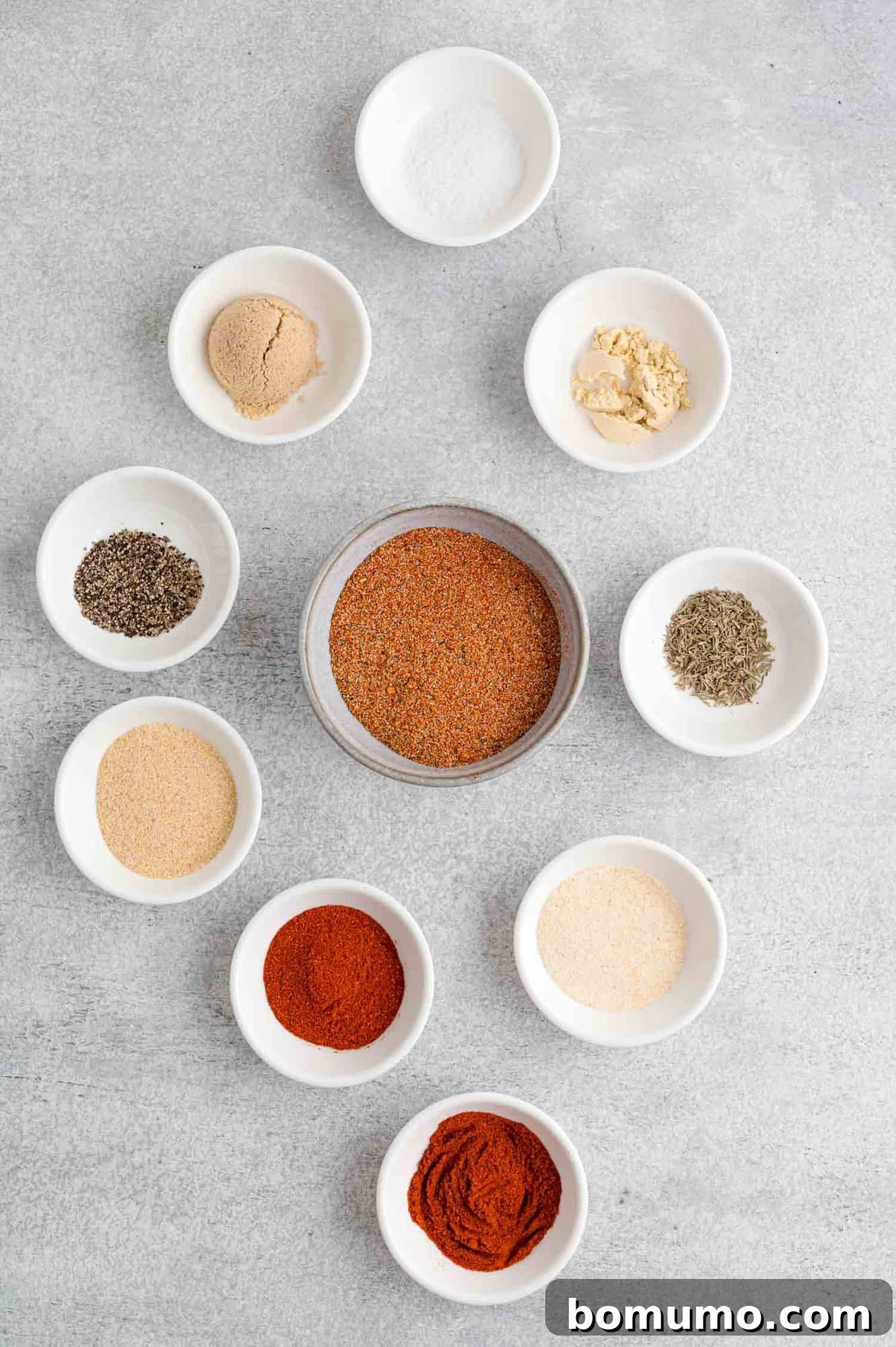 All the individual ingredients for the salmon seasoning displayed neatly in separate small bowls, showcasing their vibrant colors and textures.