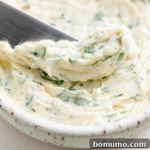 Garlic butter in a bowl and on a small knife, highlighting its rich texture and readiness for use.