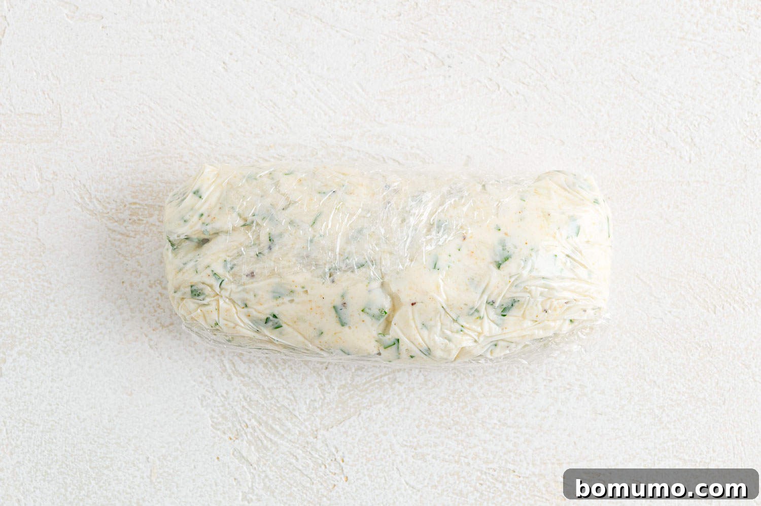 Garlic butter rolled into a log shape with plastic wrap.