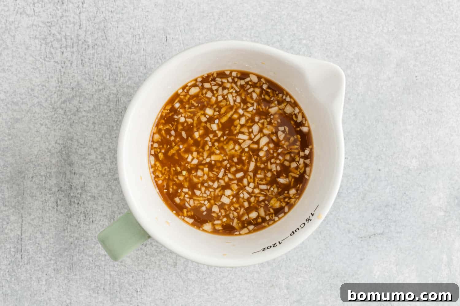 All teriyaki sauce ingredients perfectly mixed together in a white measuring cup, ready to be cooked.