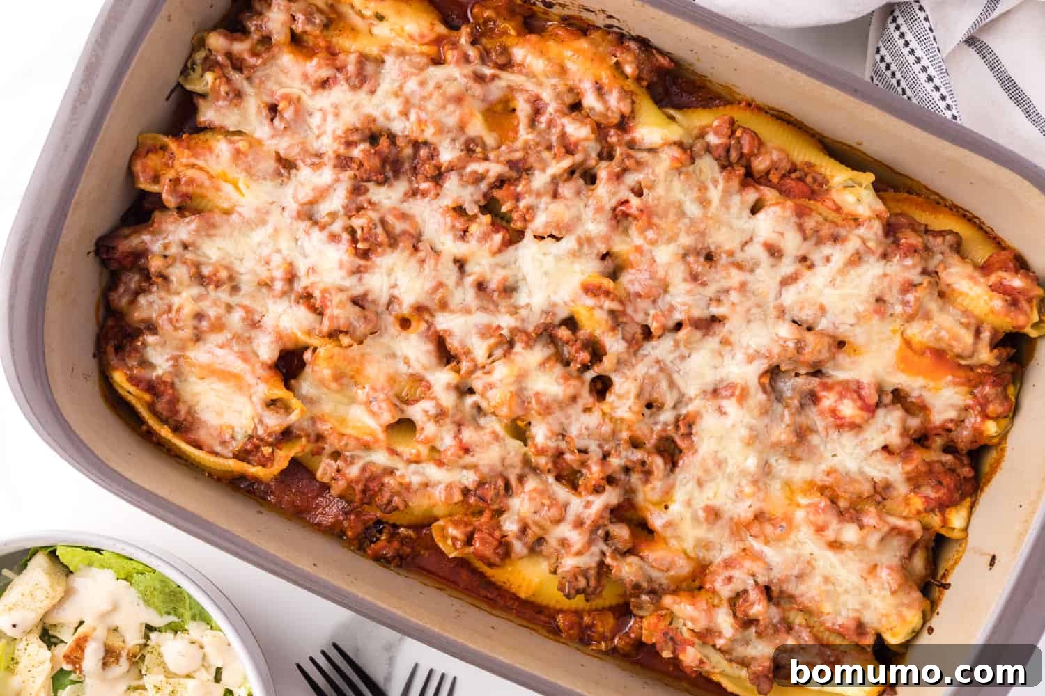 Savory Meat-Filled Jumbo Shells 14 A beautifully baked dish of stuffed shells, golden and bubbling, garnished with fresh parsley, ready to be served as a comforting meal.