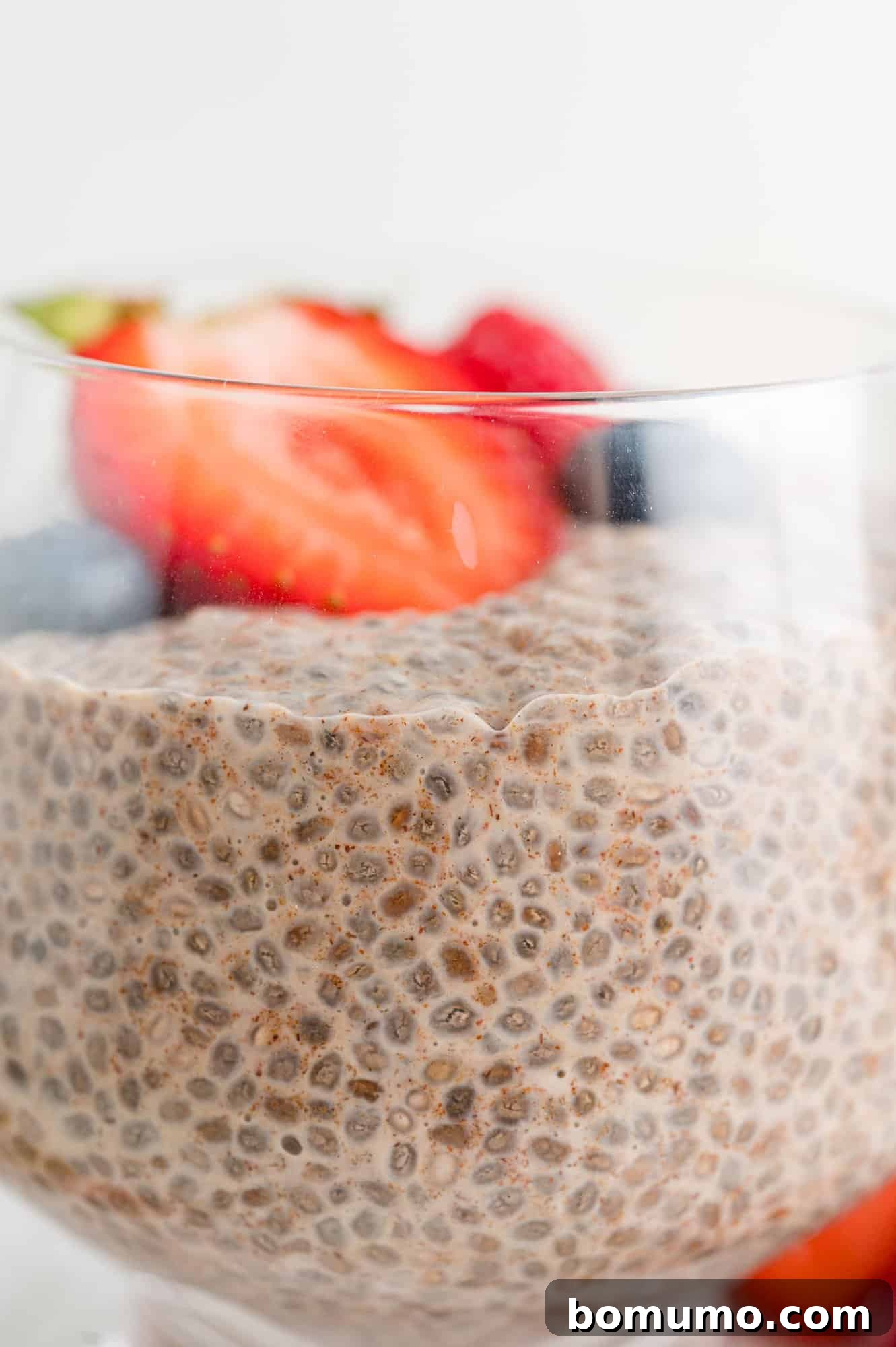 Side view of chia seed pudding in a glass jar to show its thick, creamy texture.