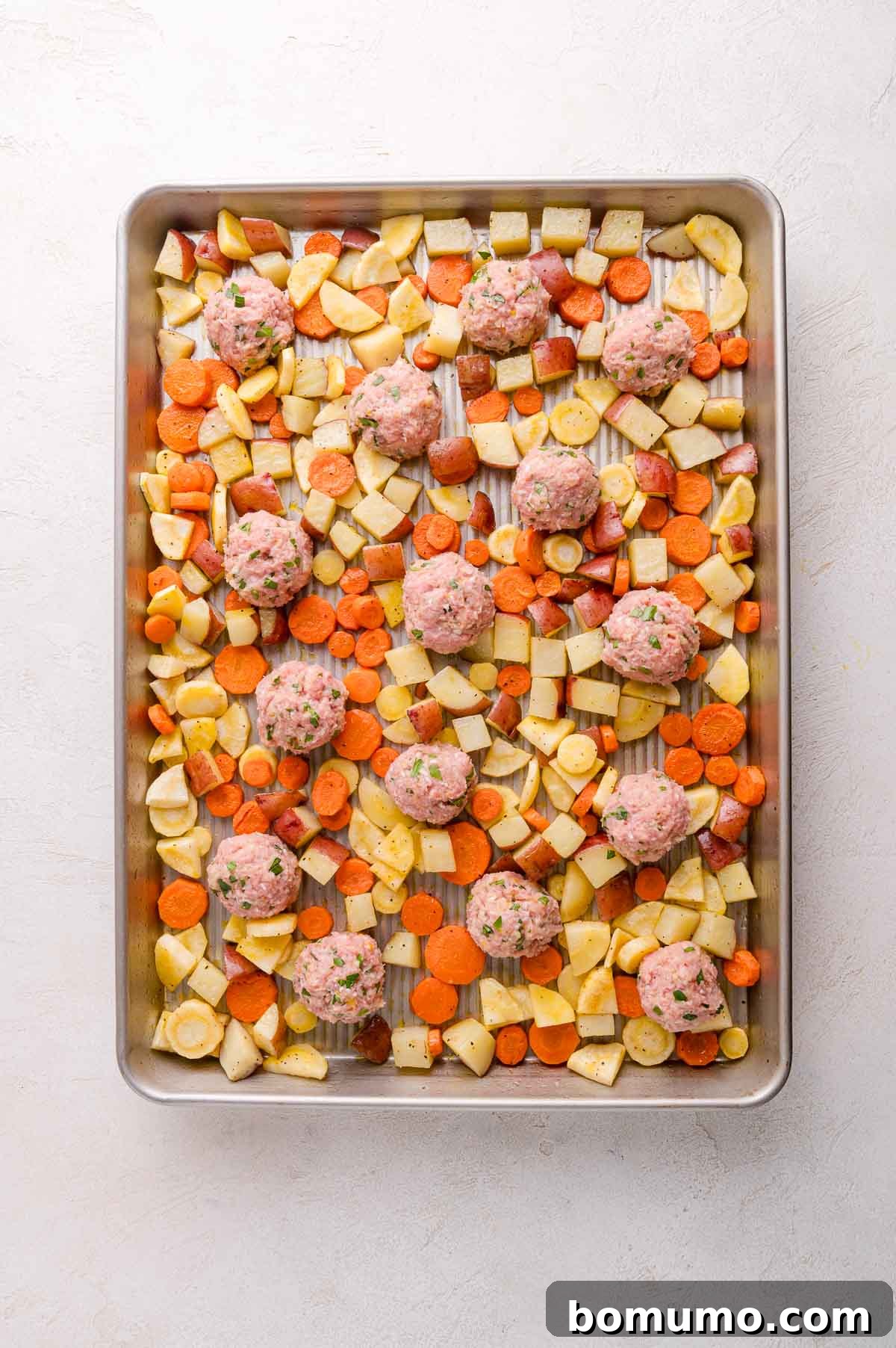 Meatballs and Vegetables on a Baking Sheet Ready to Cook