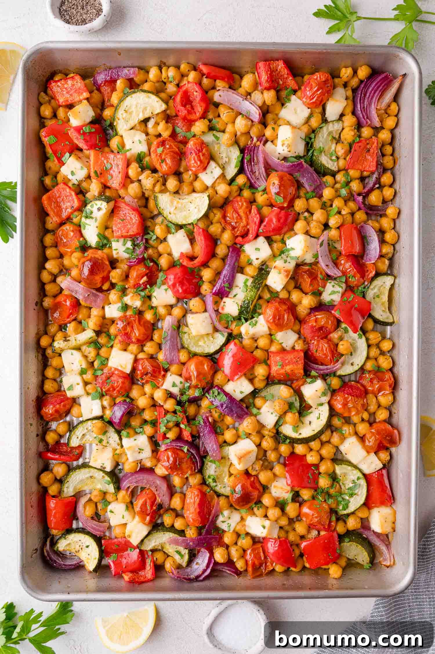 Roasted Mediterranean Chickpea and Halloumi Sheet Pan Dinner garnished with parsley.