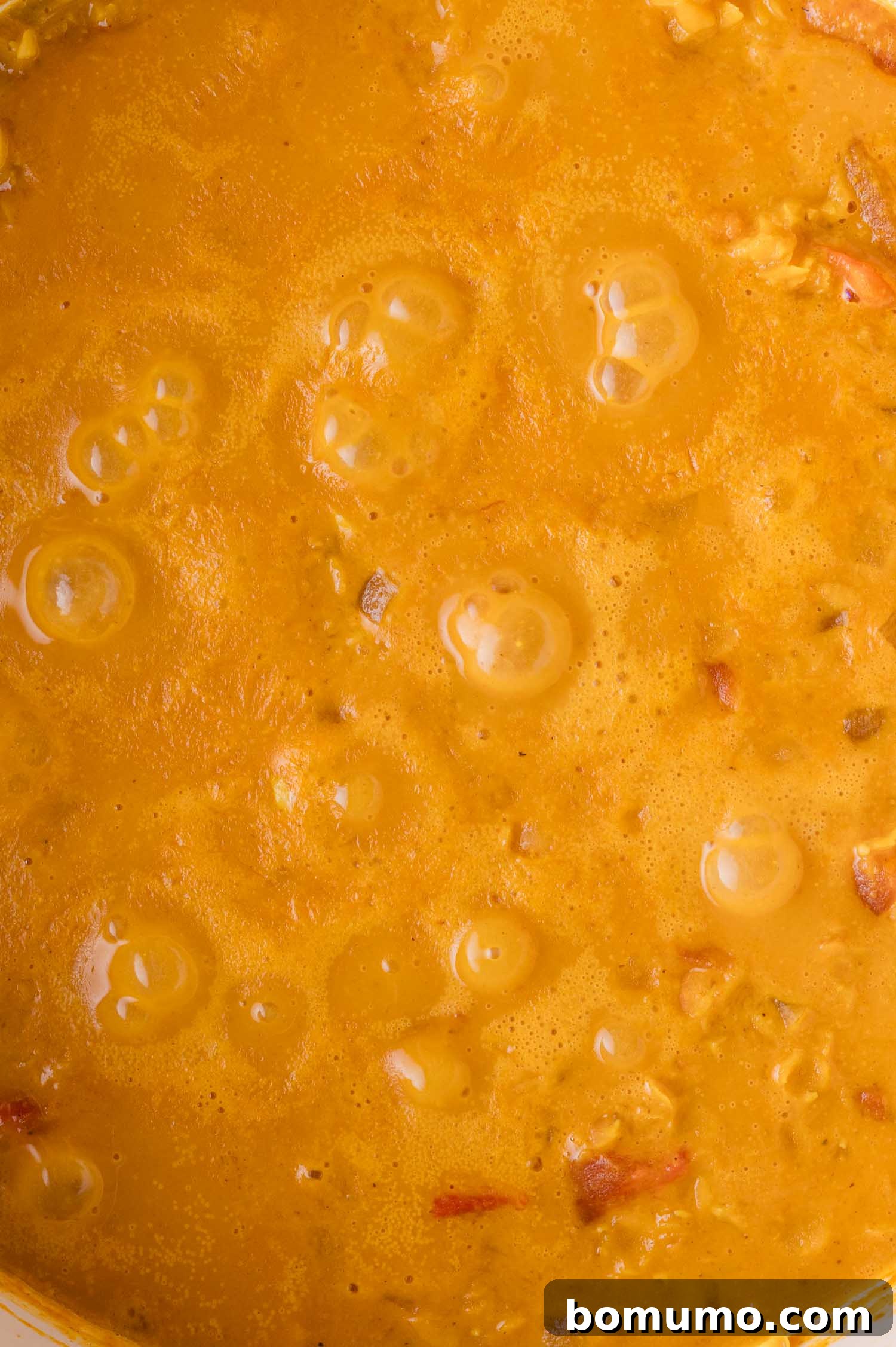Simmering red lentil curry until thickened