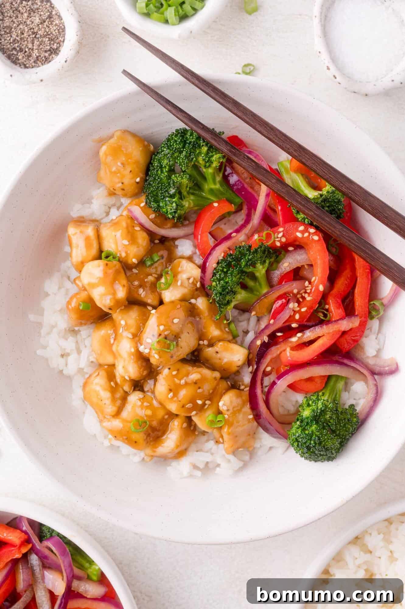 Teriyaki Chicken Bowl: White rice topped with sesame chicken, broccoli, red bell pepper, and red onion.