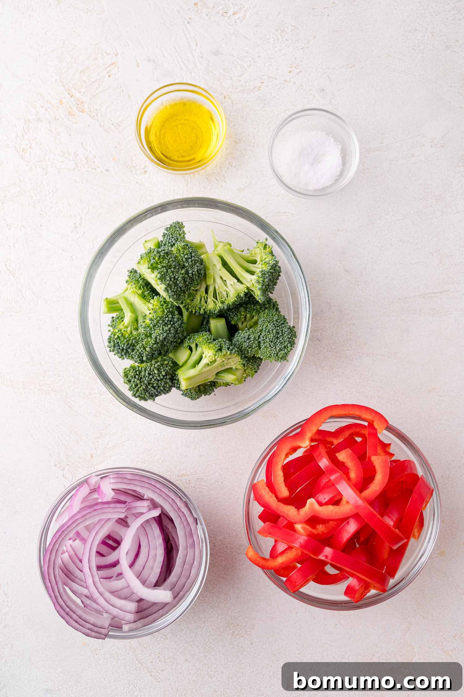 Veggie Prep: Bowls containing broccoli, red bell pepper, and red onion, with dishes of olive oil and salt.