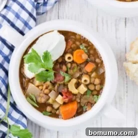 Lentil soup with pasta, topped with yogurt and cilantro.