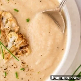 Roasted cauliflower soup topped with roasted cauliflower and chives.