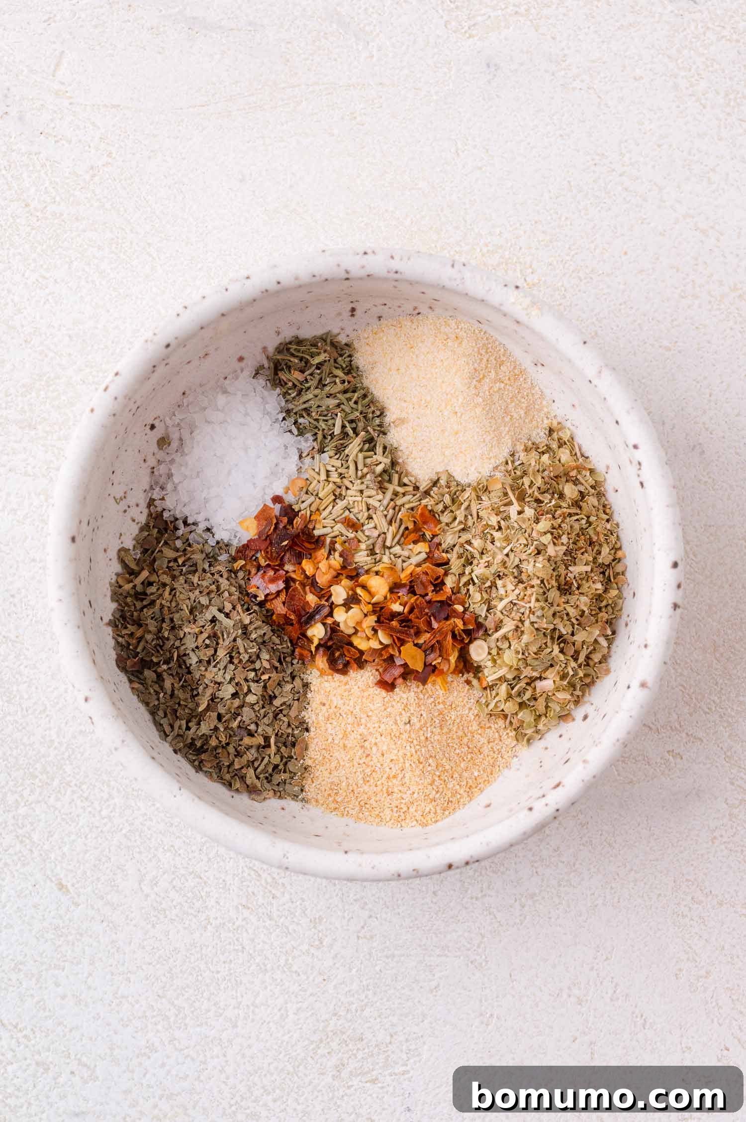 Separate piles of pizza seasoning ingredients