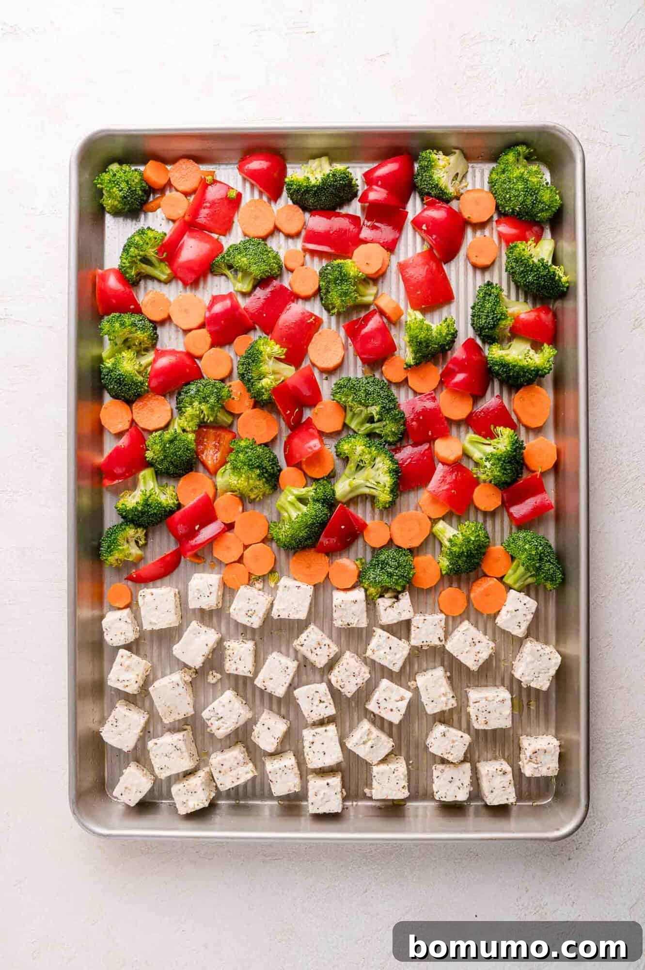 Sheet pan with tofu and vegetables ready to bake