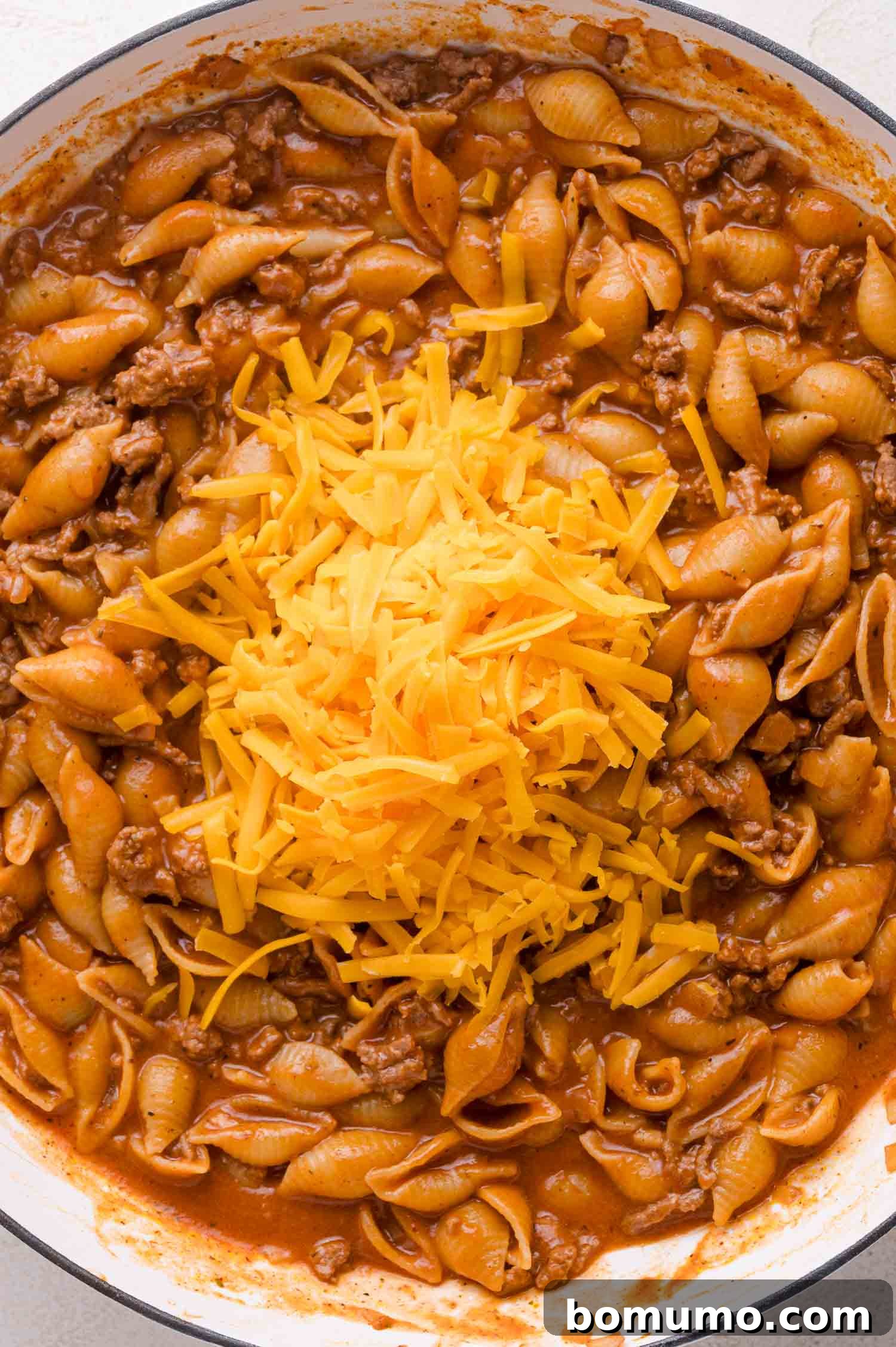Shredded cheese on top of cooked Pasta