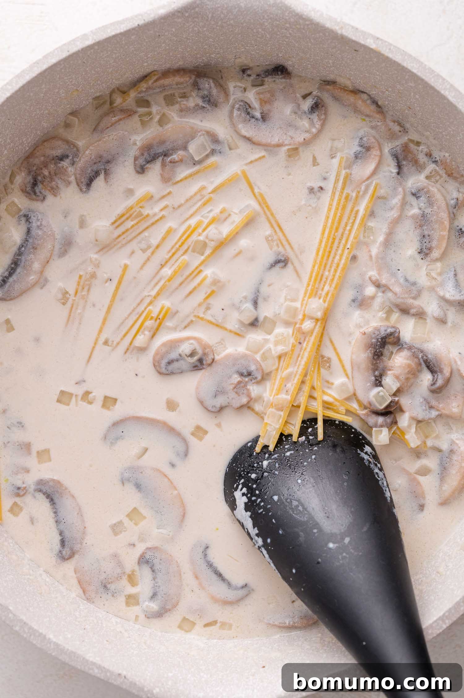 Adding spaghetti to sauce