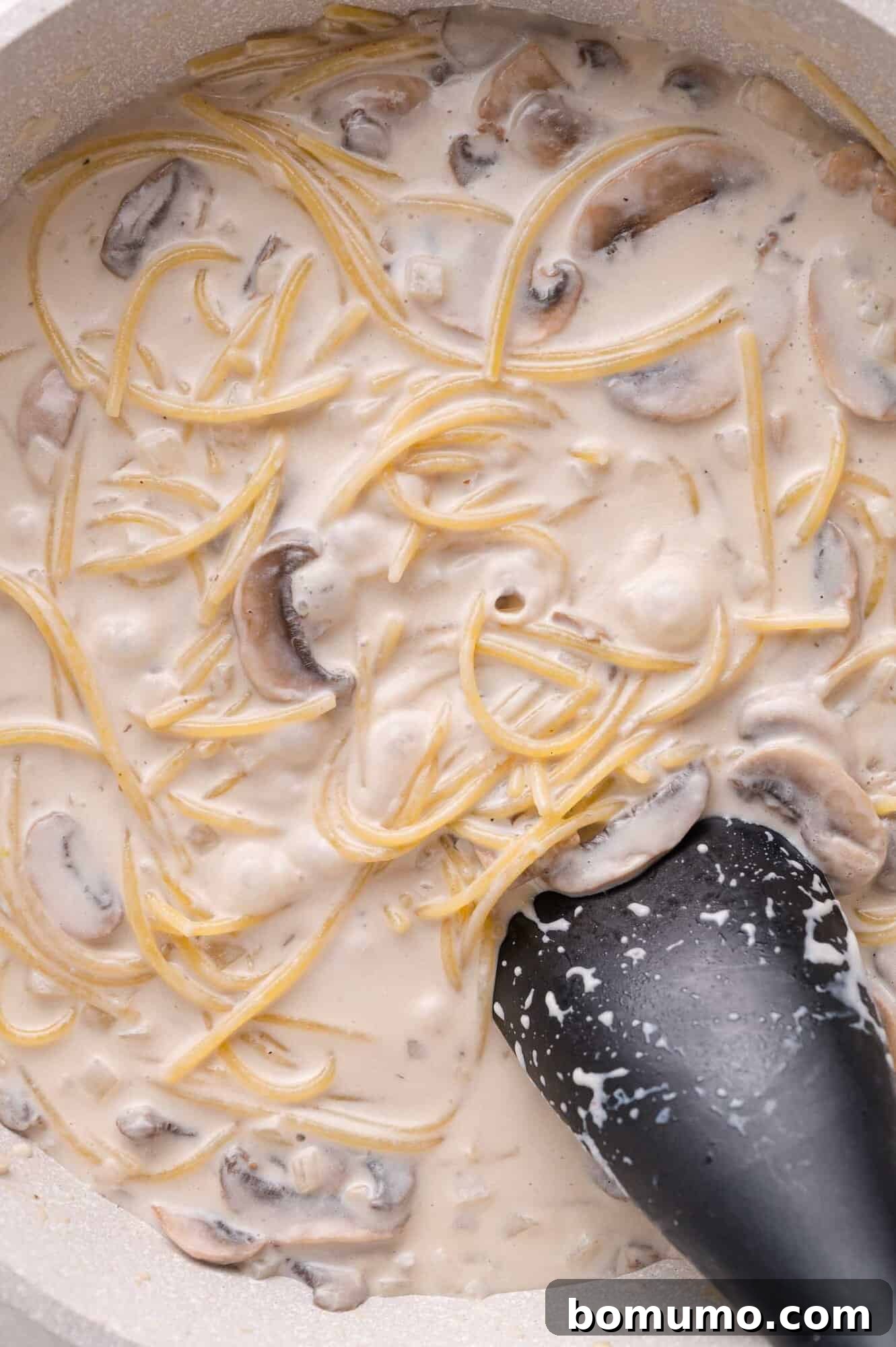 Simmering pasta in sauce