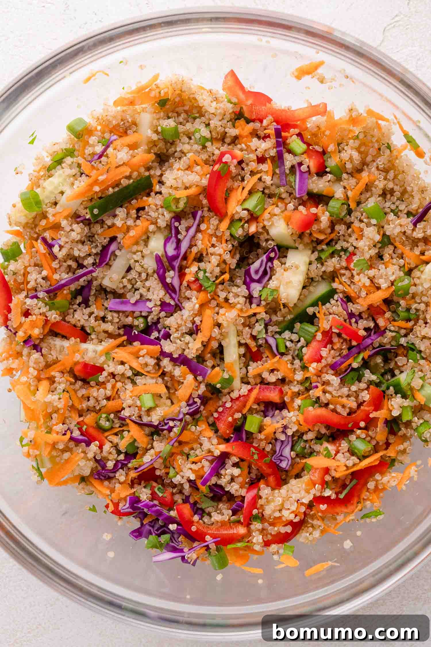 Mixing quinoa and colorful vegetables in a bowl