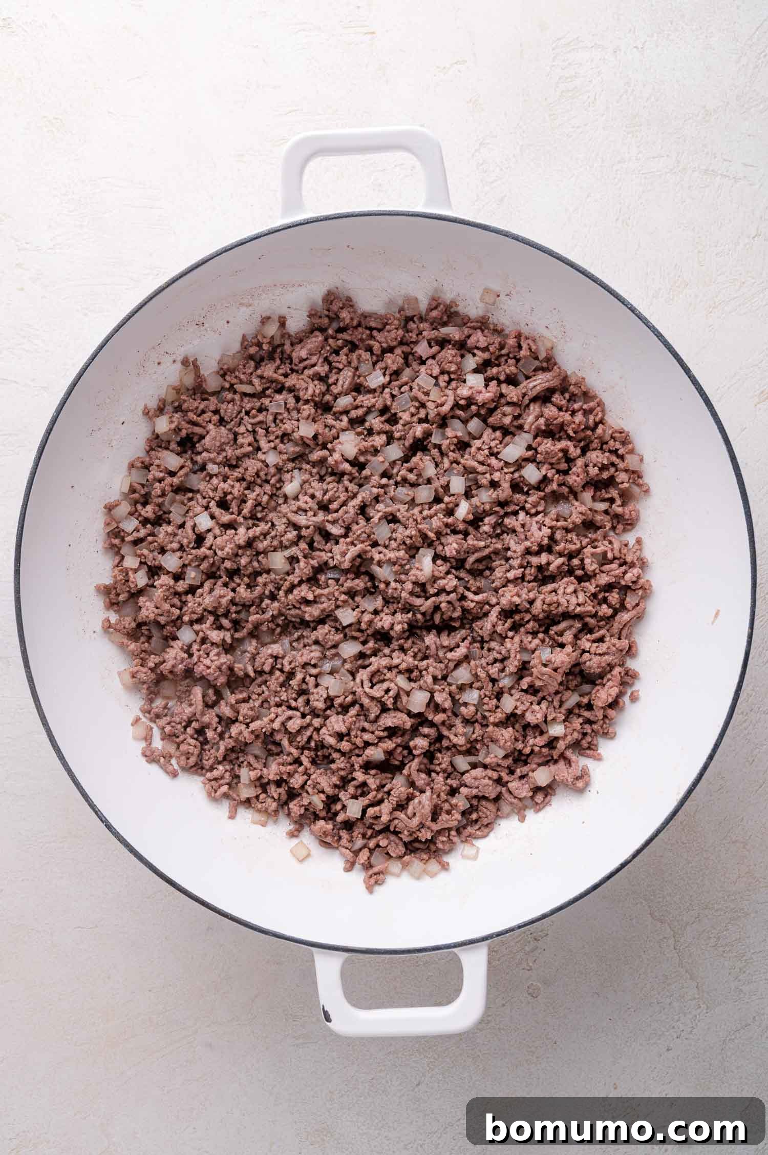 Cooked ground beef and onions in a Dutch oven.