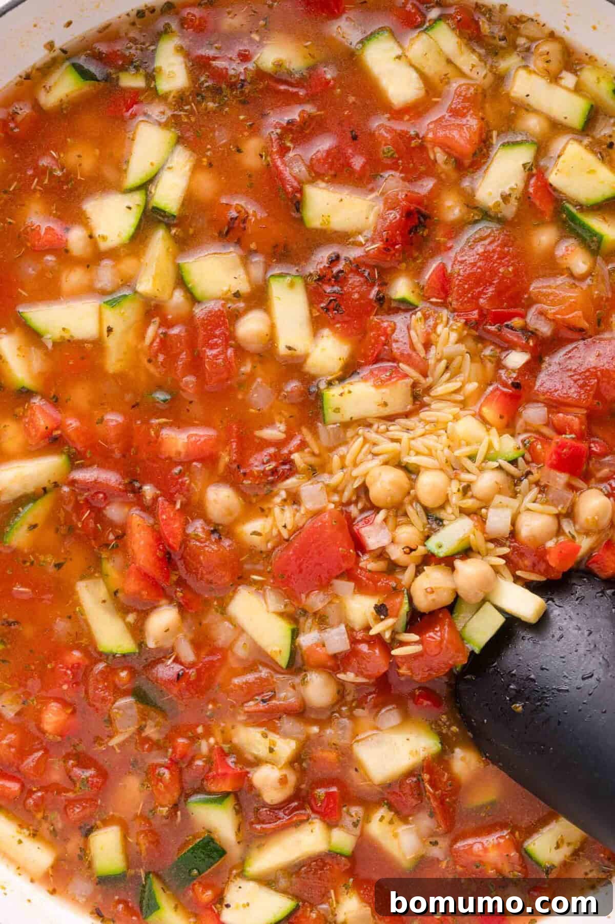 Simmering orzo with vegetables and broth