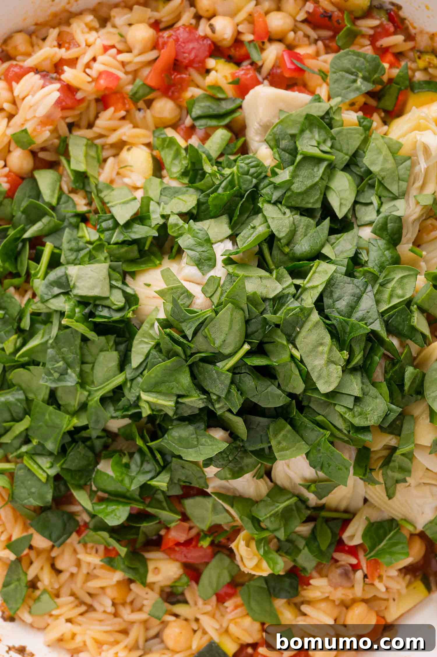 Adding spinach to orzo mixture