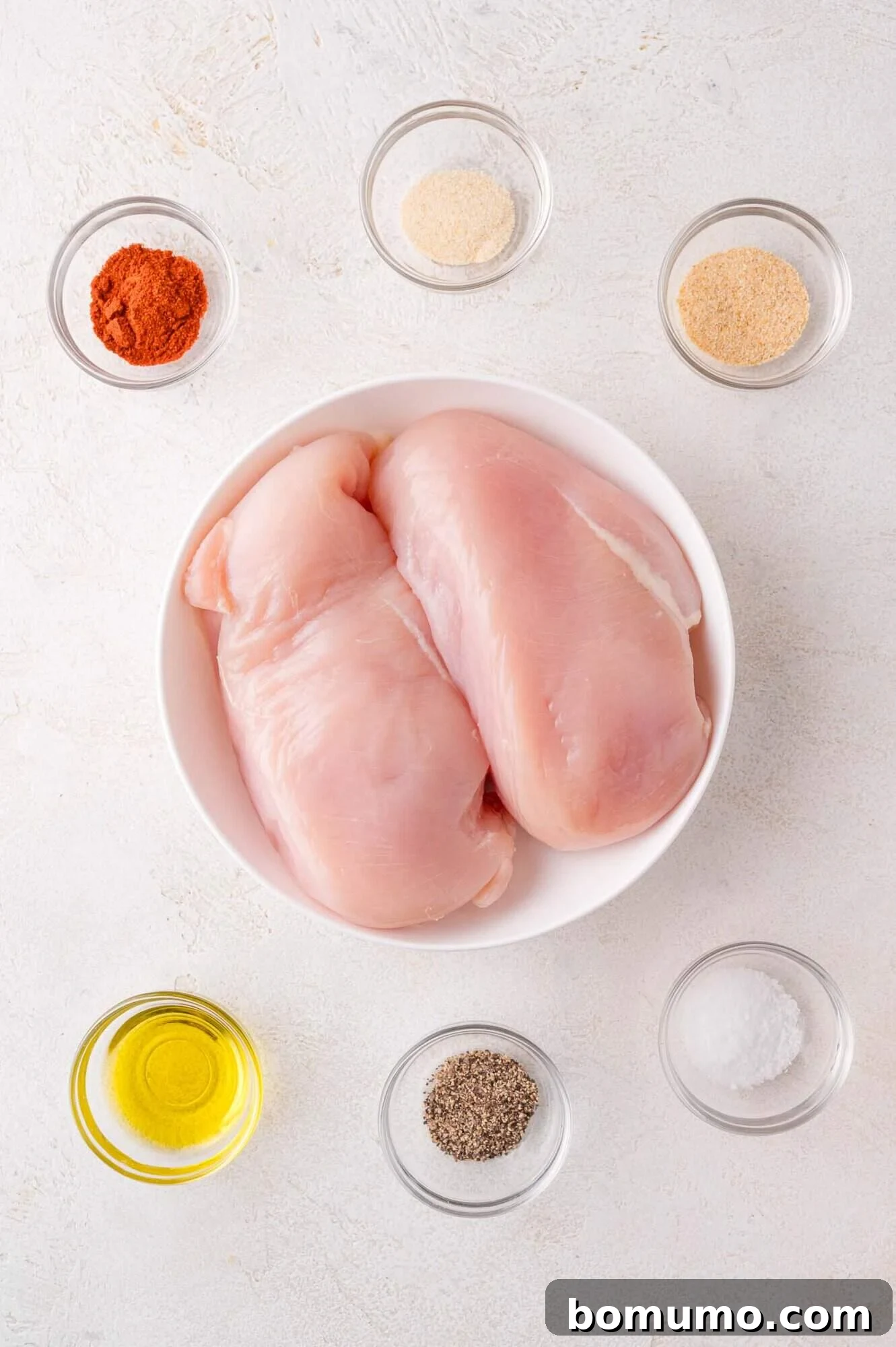 Ingredients for baked chicken breast: chicken, olive oil, and spices.