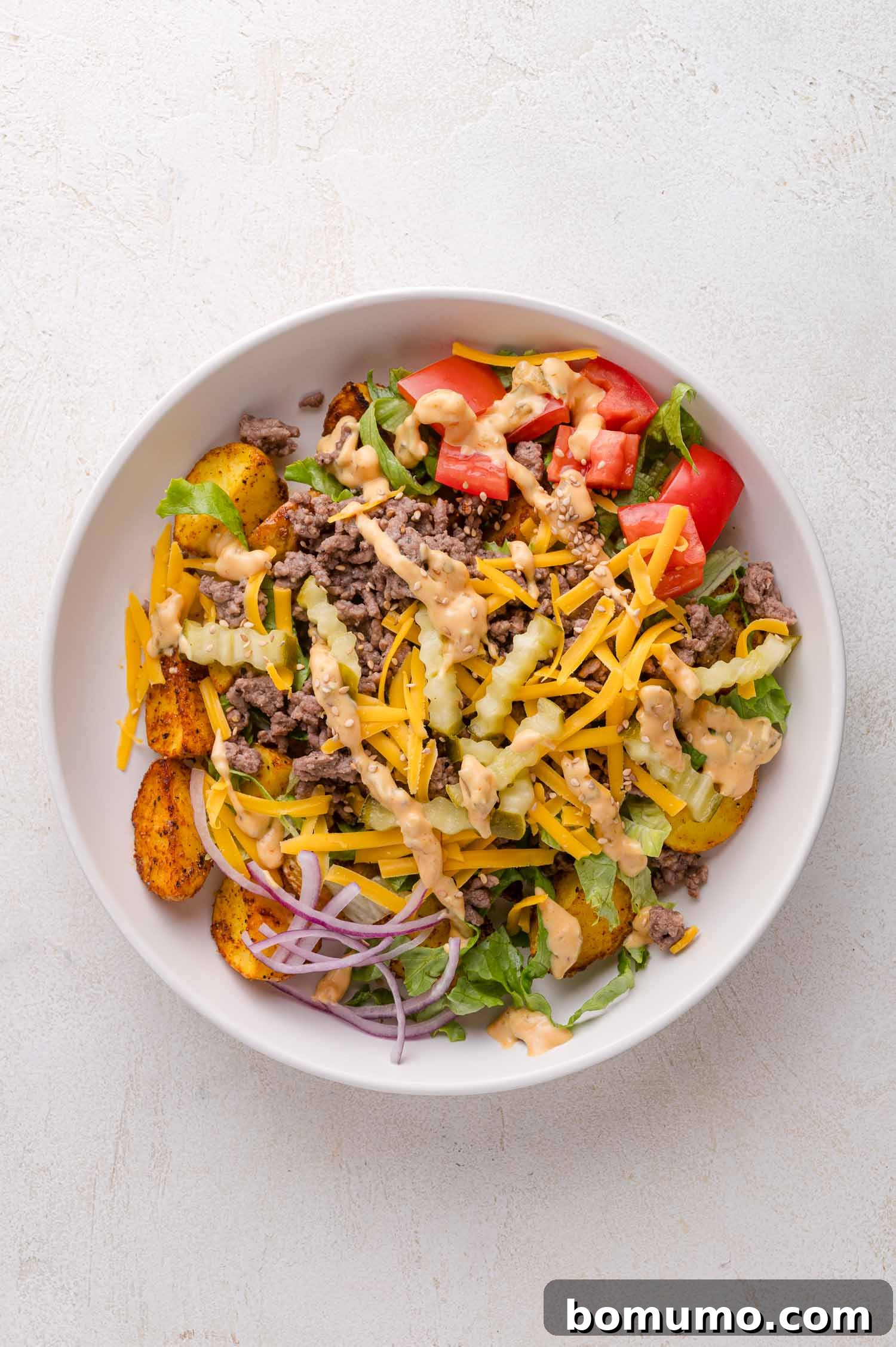 Complete burger bowl with all toppings and sauce.