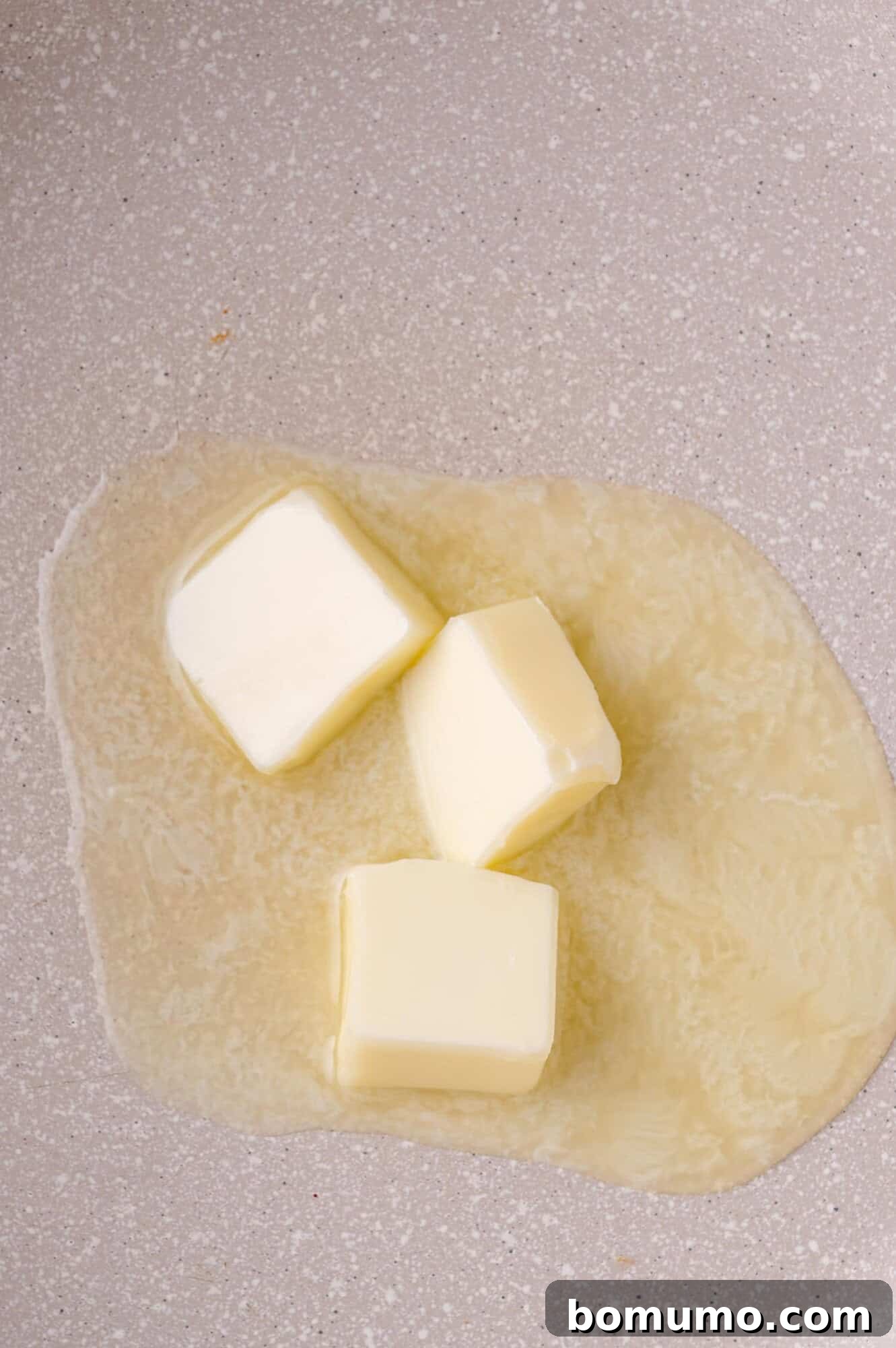 Golden Lemon Butter Cod 7 Cubes of butter melting in a clean skillet over low heat.