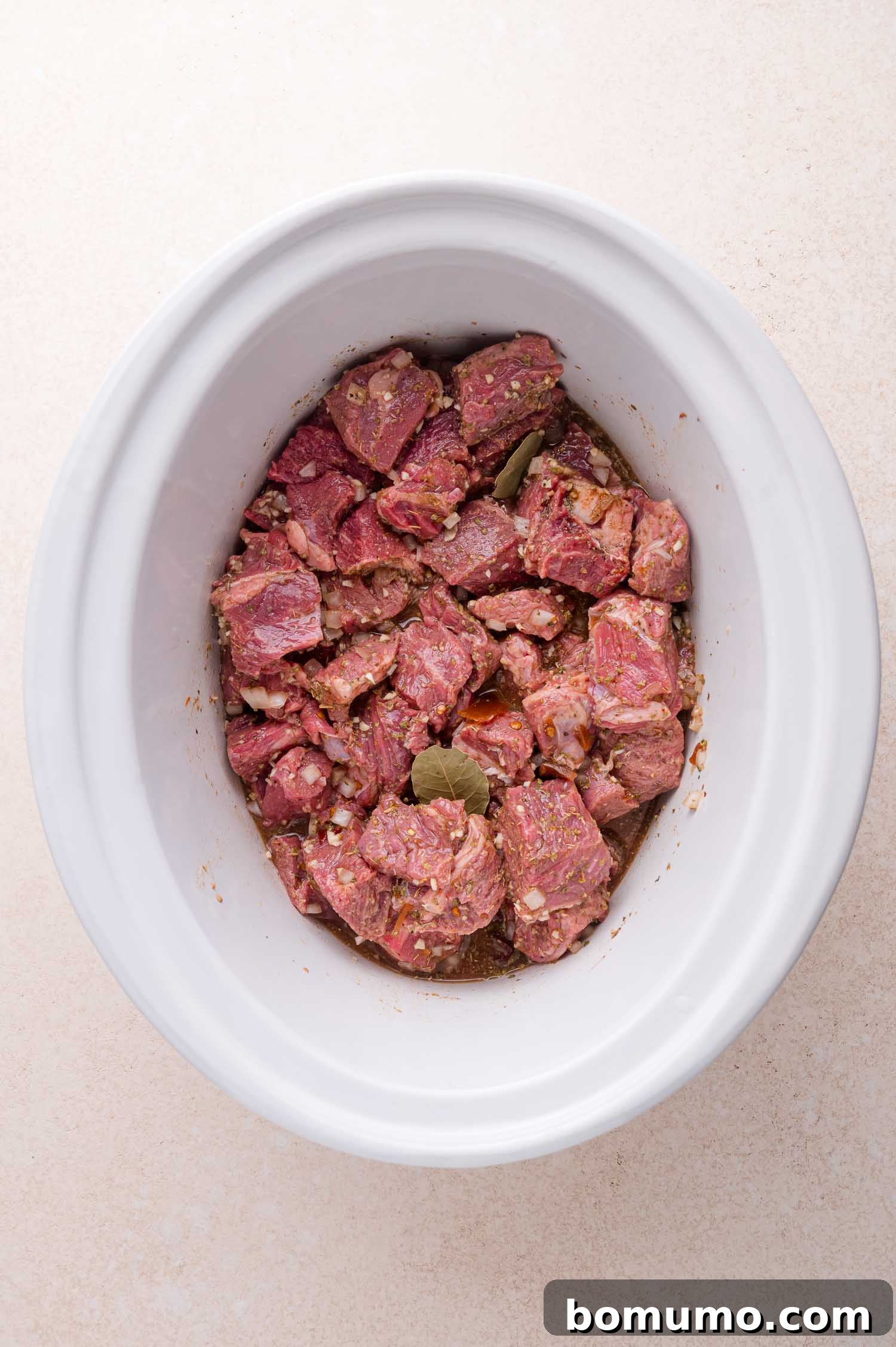 Effortless Shredded Barbacoa 9 The beef is fully coated in the marinade with bay leaves tucked in, ready for slow cooking.