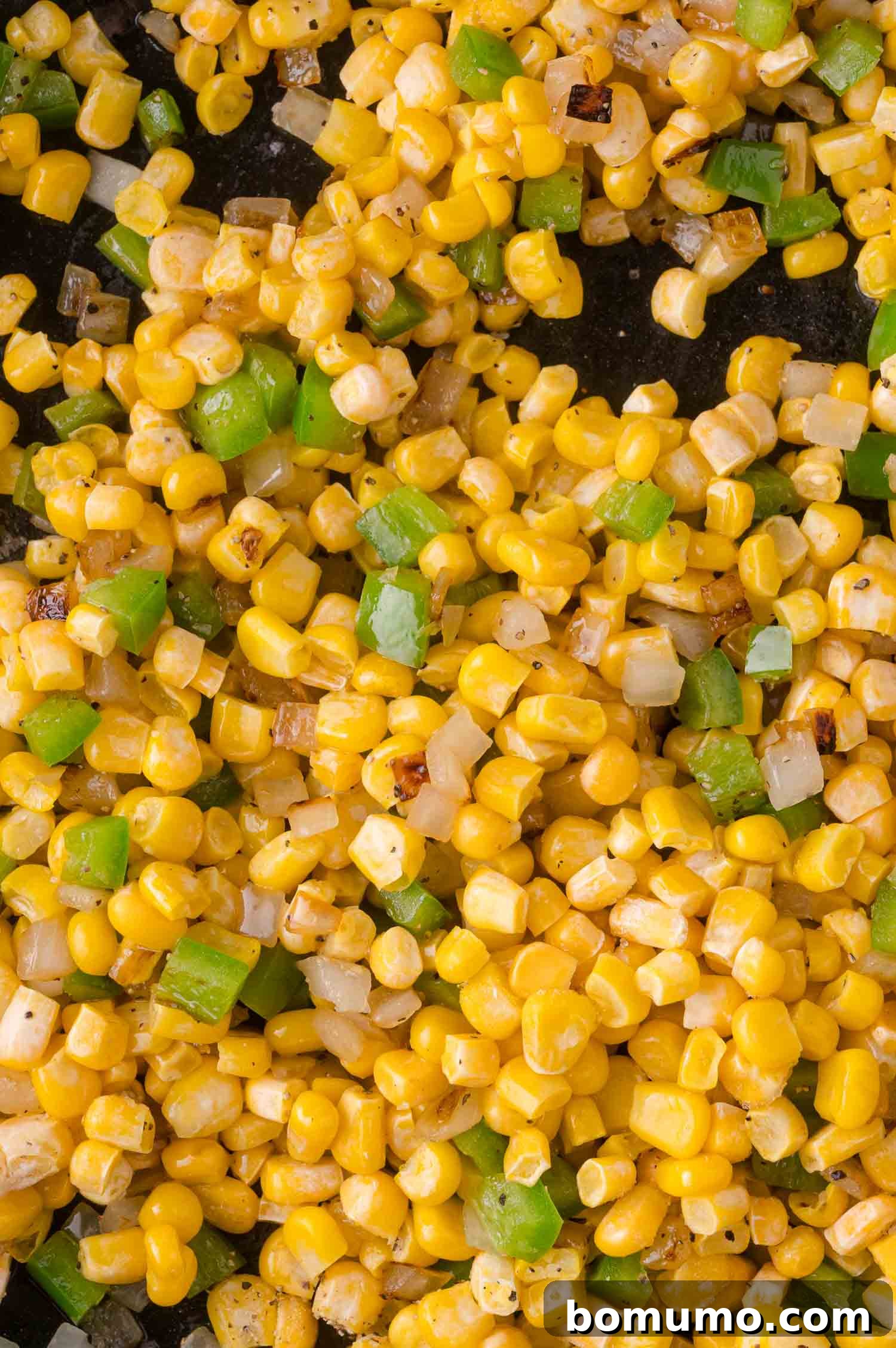Close-up of sautéed corn mixed with chopped jalapeno and onions.