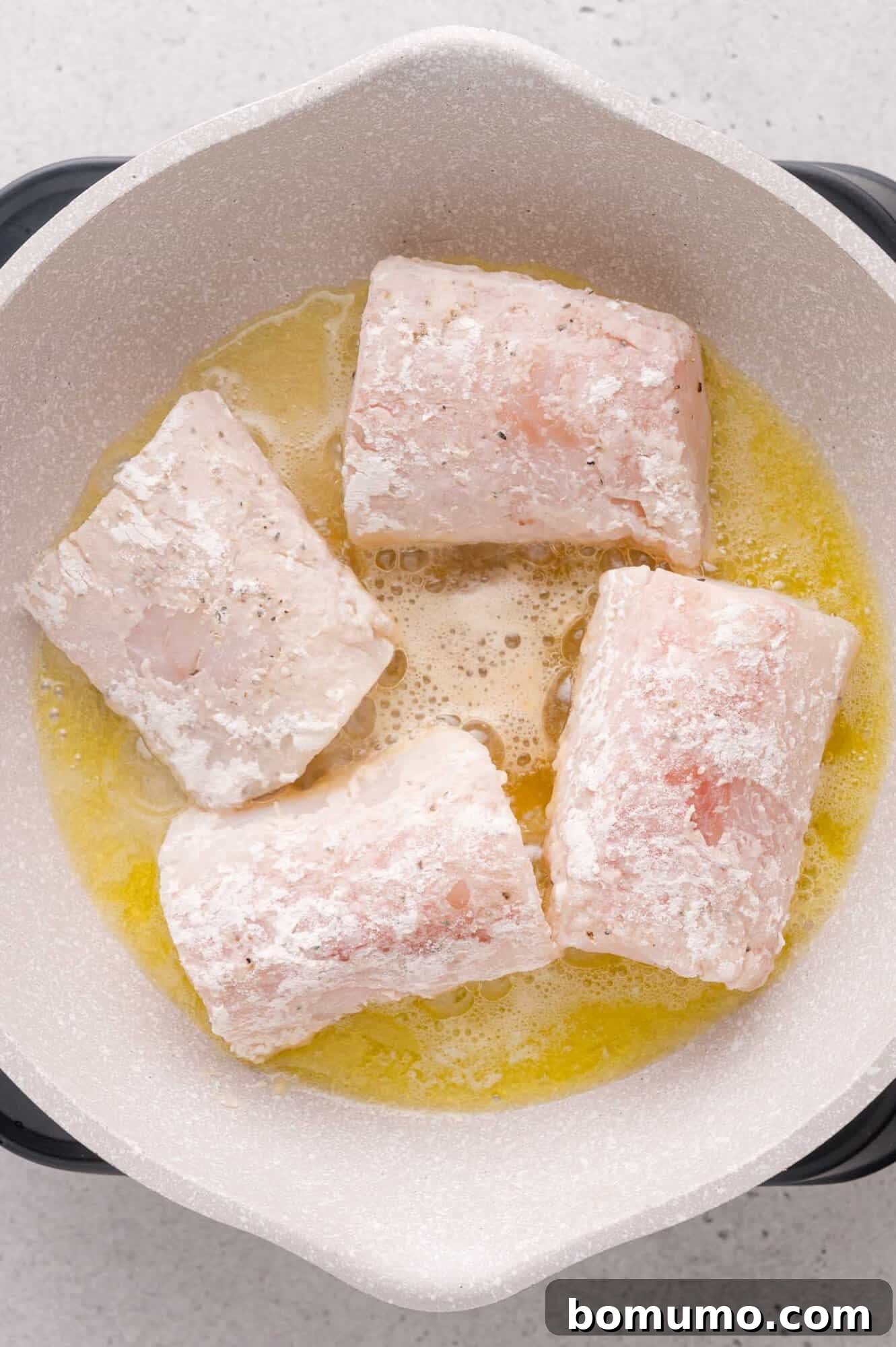 Lemon-Caper Cod Piccata 8 Floured cod cooking in a pan.