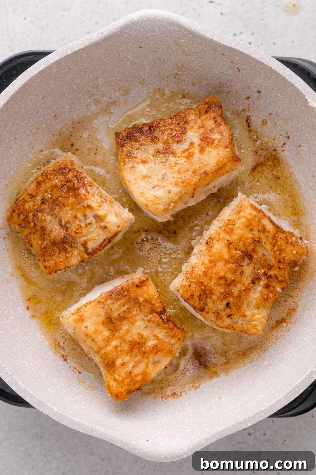 Lemon-Caper Cod Piccata 9 Pan-seared cod pieces with browned edges.