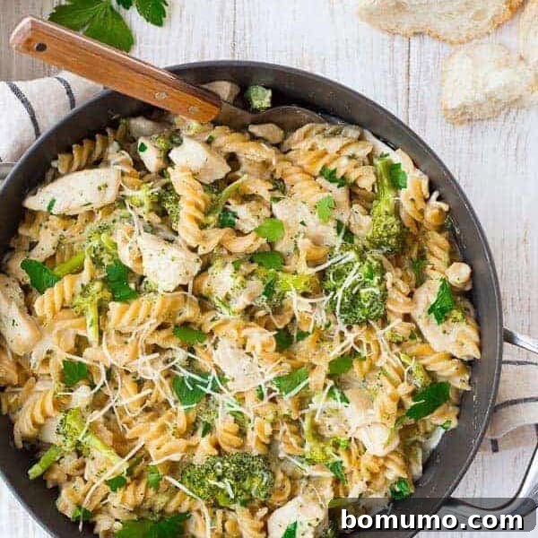image of one pan chicken alfredo recipe with broccoli, wooden spoon