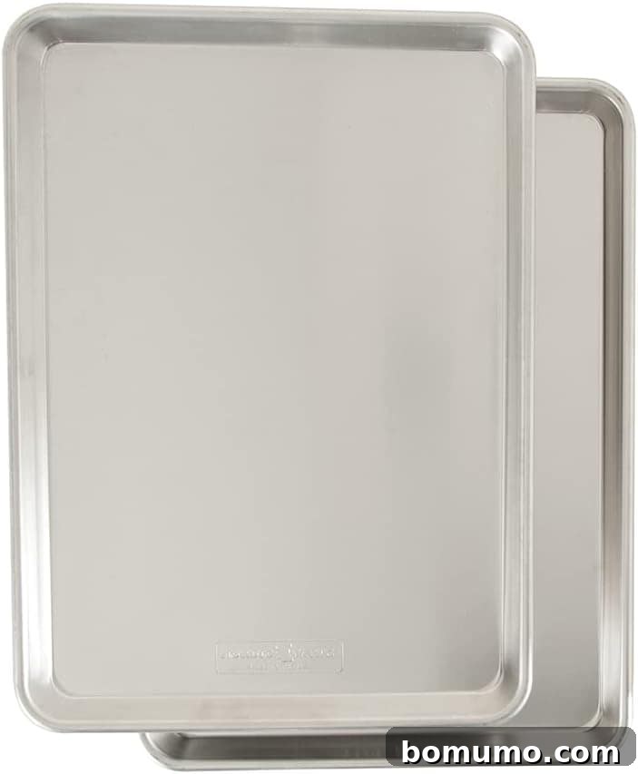 Two stainless steel baking sheets, ideal for preparing dishes like General Tso's tofu, are stacked slightly on top of each other against a plain white background.