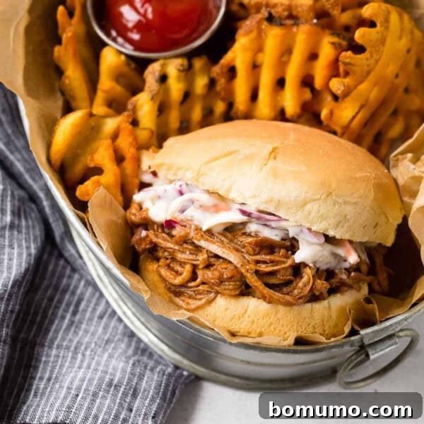 Slow Cooker Apple Cider Pulled Pork Sandwiches 13 Instant Pot Pulled Pork on a bun with slaw and fries in a basket.