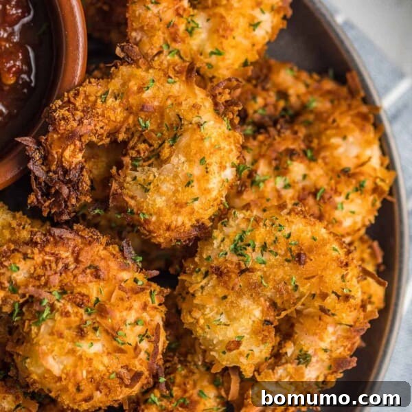 Garlic Butter Shrimp Scampi with Lemon and Parsley 14 Pile of coconut shrimp on a plate with dipping sauce.