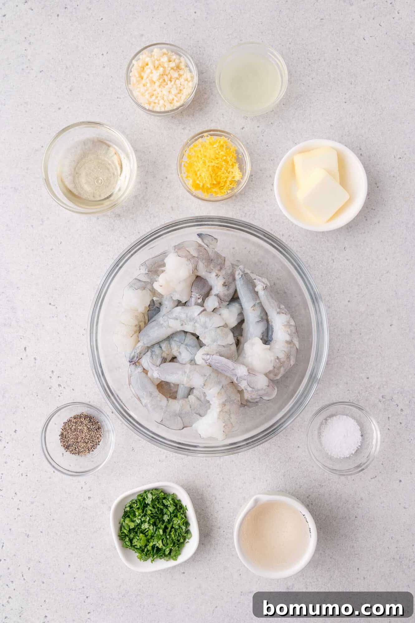 Garlic Butter Shrimp Scampi with Lemon and Parsley 3 Raw shrimp and ingredients displayed in bowls: garlic, lemon zest, lemon juice, butter, salt, pepper, parsley, white wine.
